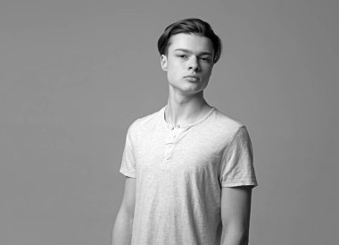 Işık gömlek, gri arka planda emin yüz adam. Maço şık uzun saç kesimi ile. Erkeklik kavramı. Adam kameraya, kopya alanı arıyor yüzündeki pürüzsüz bir cilt ile.