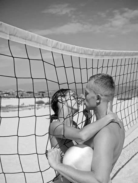 Szerelmes pár röplabdázik a sunny beach. szerelmes pár csók, strand röplabda-háló tartja a labdát. — Stock Fotó