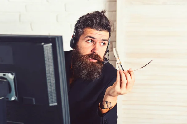 Calm and professional. Bearded man working in office. Man with long beard and headphones. Bearded company representative at computer. Call center operator at work. Responding the calls from customers