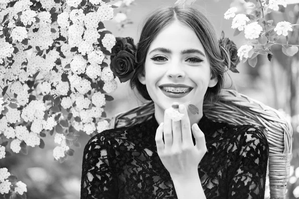 Жінка посміхається з білою квіткою в роті — стокове фото