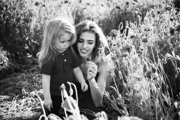 Rouge et vert, mère et enfant souriants dans le champ de pavot — Photo