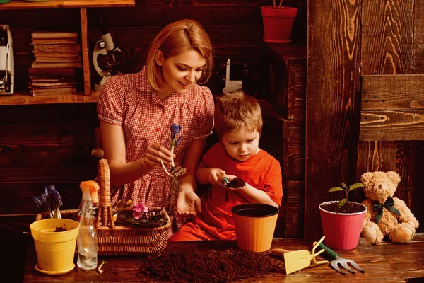 Květinový koncept. Malý syn pomoc matka výsadbu květin v hrnci, květinové výzdobě. Matka a dítě pracovat na aranžmá. Květinový design — Stock fotografie