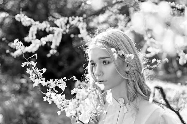 Menina no rosto sonhador, loira macia perto de flores violetas de judas árvore, fundo da natureza. Jovem mulher gosta de flores no jardim, desfocado. Lady caminha no parque no dia ensolarado da primavera. Conceito de flor de primavera . — Fotografia de Stock