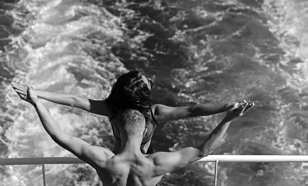 Jovem casal de mãos levantadas no navio em trilha de água . — Fotografia de Stock