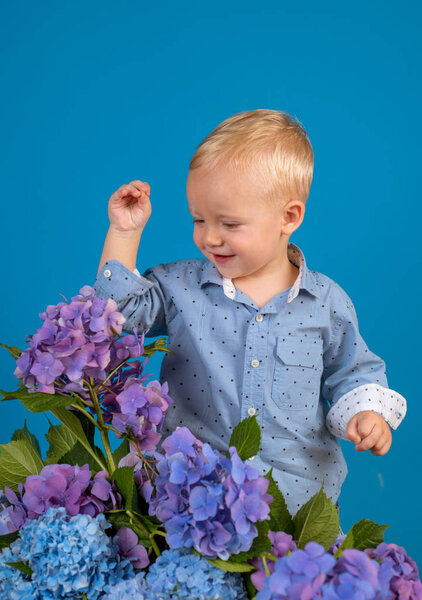 Little boy at blooming flower. Childrens day. Small baby boy. New life concept. Spring holiday. Summer. Mothers or womens day. Spring flowers. Childhood. Enjoying every moment