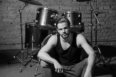 Beat sizinle olsun. Rock konser müzik kulübü provada. Yakışıklı adam vurmalı enstrüman aşamada oturamaz. Müzik aleti, adam davulcu. Enstrümantal müzik keyfi. Rock yıldızı ya da rock'çı