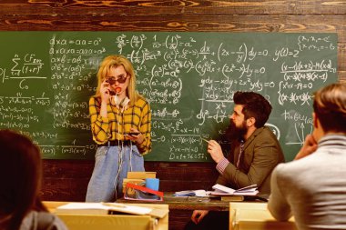 Öğretmen raporları yetenekli öğrencilerin hataları düzeltmek gönüllülük gözlük. Özenli öğrenciler bir şey onların Not pads, masaları sınıfta otururken yazma.