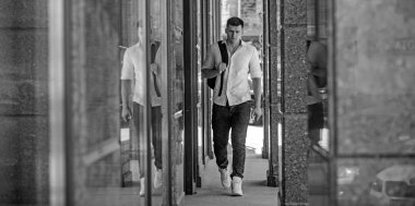 Tatilde sırt çantası ile adam yürümek. Adamla seyahat çantası üzerinde kentsel açık