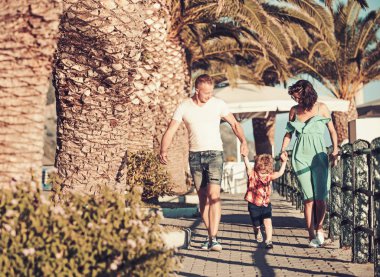 Anne ve baba ile oğul plaj palms adlı yürümek. Mutlu bir aile tatil yaz. Sevgi ve güven aile değerleri olarak. Çocuk Anne ve baba ile. Aile Anne ya da babalar gününde çocukla seyahat.