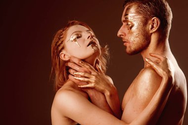 Şehvetli çift erotik oyun sahip. şehvetli çift altın vücut ile kucaklamak.