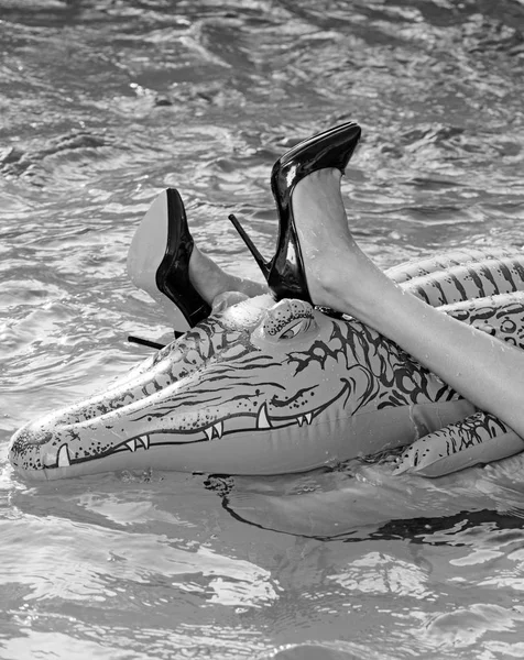 Μόδα παπούτσια από δέρμα κροκοδείλου. Παπούτσια από δέρμα κροκόδειλου. γυναίκα στη θάλασσα με φουσκωτό στρώμα. γυναικεία πόδια κρατήστε στρώμα στην πισίνα. Περιπέτειες του κοριτσιού στην κροκόδειλος σε καλοκαιρινές διακοπές. — Φωτογραφία Αρχείου
