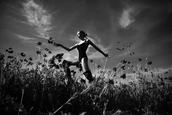 summer girl jump in flower field of poppy seed