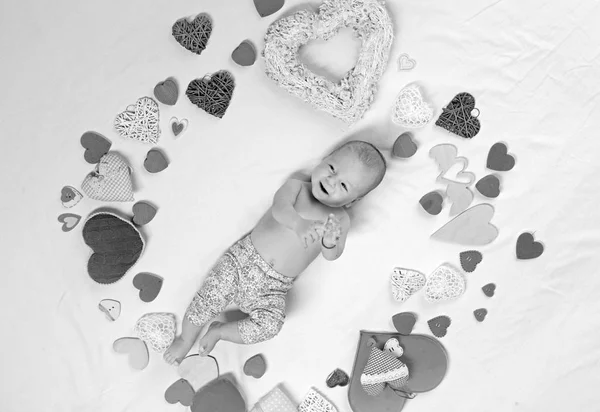 De dag van Valentijnskaarten aanwezig. Lieve kleine baby. Nieuw leven en geboorte. Klein meisje onder rode harten. Familie. Kinderopvang. Liefde. Portret van gelukkig klein kind. Jeugd geluk. Valentijnsdag — Stockfoto