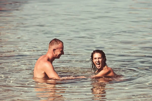 Feliz joven pareja divirtiéndose, hombre y mujer en el mar en la playa. estilo retro vintage — Foto de Stock