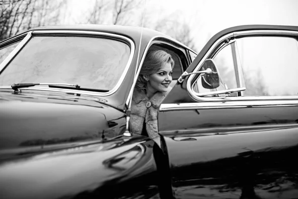 Retro collection car and auto repair by driver. Travel and business trip or hitch hiking. Escort and security guard for luxury woman. sexy woman in fur coat. Call girl in vintage car Stock Image