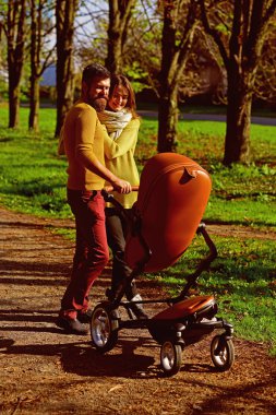 Sonbahar parktan Aile bağı yürürken kadın ve adam üst itme bebek arabası. Mutlu aile bağı. Beraberlik bir zevk