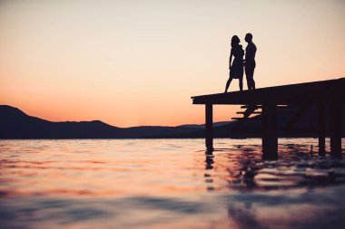 Genç çift günbatımı plaj zevk siluet