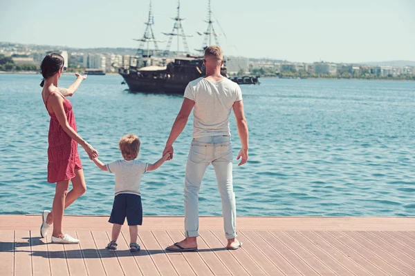 息子父と母は、船で湾を見てください。母親と父親子供息子の手を握るし、船を見て. — ストック写真