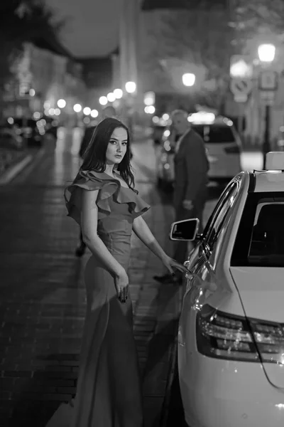 Роскошная женщина в вечернем платье в ночном городе едет на бал на такси. роскошная женщина в красном платье подождите такси . — стоковое фото