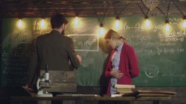 Güzel genç öğrencilerin büyük yazı tahtası önünde. Onun genç kız öğrencinin matematik ile yardımcı ders. Özel eğitim kavramı. Sınıf arkadaşım bilgi ders kavramı eğitmek. Öğretmen ve öğrenci