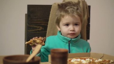 Pizza yemek çocuk kapatın. Lezzetli pizza. Sevimli küçük beyaz çocuk pizza yemek. Pizza tarafından bir ısırık alarak aç çocuk.