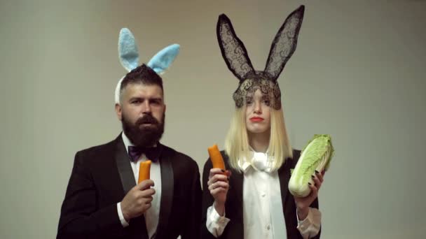 Funny easter bunny. Happy funny easter couple with carrot. Family celebrate Easter. Easter rabbits. Couple with bunny ears.