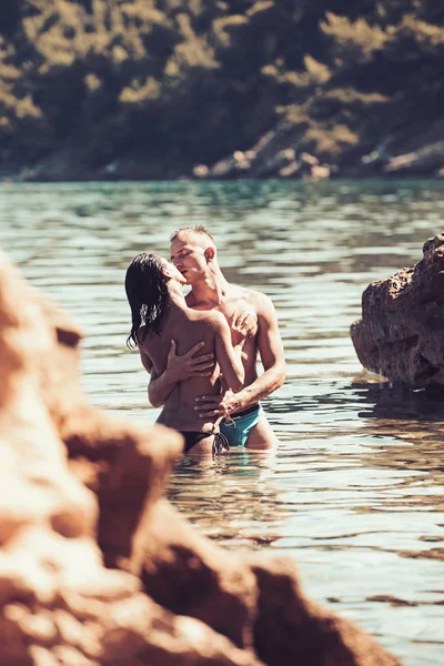 Vacaciones de verano y viajes de vacaciones. Las relaciones amorosas de la pareja desnuda en el agua de mar. Concepto de familia y día de San Valentín. Mujer sexy y el hombre tienen juegos sexuales. Pareja enamorada de sexy cuerpo relajarse en la playa — Foto de Stock