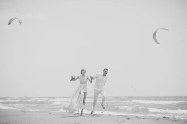 Düğün çifti kumsalda atlama