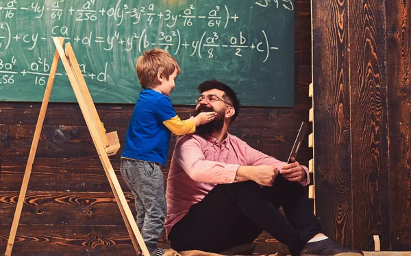 Concetto di istruzione informale. Ragazzo che gioca con i baffi di papà o insegnante. Divertirsi alla lezione — Foto Stock