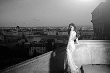 Şehir Manzaralı, moda akşam üzerinde beyaz gelinlik kadın. Şehvetli kadın balkonda, güzellik uzun saçlı. Gelin Makyaj ile. Kız Düğün glamour bakışla