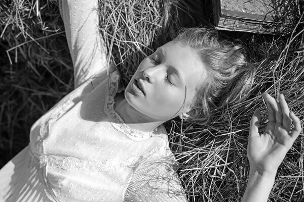 Albino girl sleep on hay. Woman with natural look and no makeup. Sensual woman with long blond hair. Beauty model with young face skin. Look and youth.