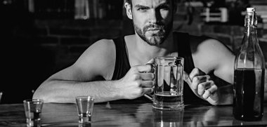 Biraz bira sahip. Bira bardağı ile alkol bağımlısı. Adam alkol barda. Yakışıklı adam içki bira bar sayacı. Bira restoran. Alkol bağımlılığı ve kötü alışkanlık. Alkollü içecek UOL