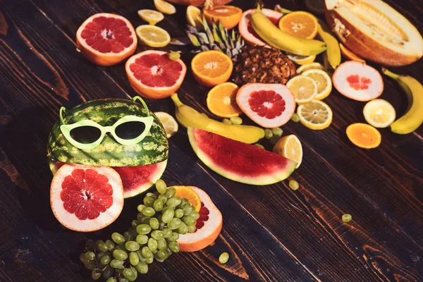 Meloun v sluneční brýle a ovoce na raw pozadí. Kreativní koncept potravin — Stock fotografie
