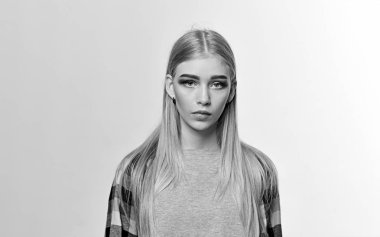 Güzel genç kadın ağır makyajlı, kalın kaşları ve kameraya bakarak uzun sarı parlayan saçları beyaz arka plan üzerinde izole