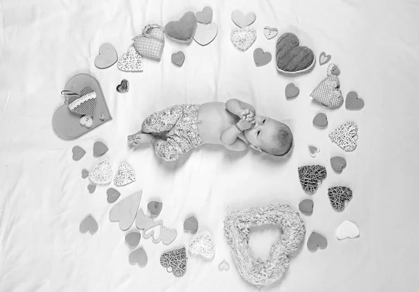 Maternal warmth. Small girl among red hearts. Love. Portrait of happy little child. Sweet little baby. New life and birth. Childhood happiness.Valentines day. Family. Child care — Stock Photo, Image