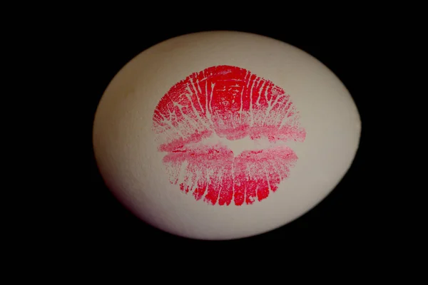 Kırmızı dudaklı beyaz yumurta üzerinde baskı. Easter egg siyah arka plan üzerinde kırmızı dudak Künye. — Stok fotoğraf