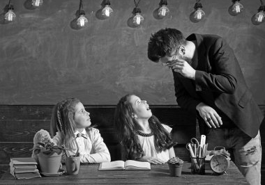 Sakallı adam ve küçük kız İlköğretim Okulu. Öğretmen kız öğrenciler sınıfta öğretmek. Çocuk öğrencilerimiz masa başında eğitim. Öğretmen ve öğrenciler, ders. Eğitim ve okul kavramı