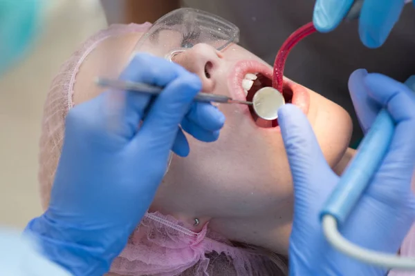 美丽的年轻女子与健康的牙齿在白色背景。一名女患者在门诊上为牙齿美白而去看牙医的特写镜头。牙科保健概念. — 图库照片