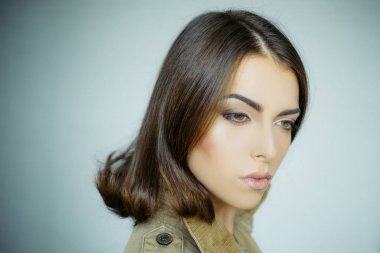 Mükemmel cilt çekici kız. Güzellik kadını Studio gri arka plan üzerinde. Yakın çekim portre. Saç şekillendirme. Makyaj, pürüzsüz bir cilt.
