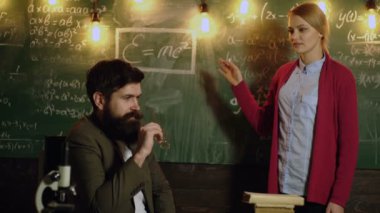 Matematik formülleri tahtaya yazma ve fikirleri tartışmak kadın ve akademik erkek. Öğretmen sınıfta. Öğretmen ve öğrenci. Öğrenme kavramı. Sınıf arkadaşı eğitmek arkadaş bilgi ders kavramı.