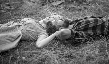 Çim üzerinde yalan ve gökyüzüne bakarak yan görünümü çift. Park veya orman genç insanlar rahatlatıcı. Yaz tatil Romantik