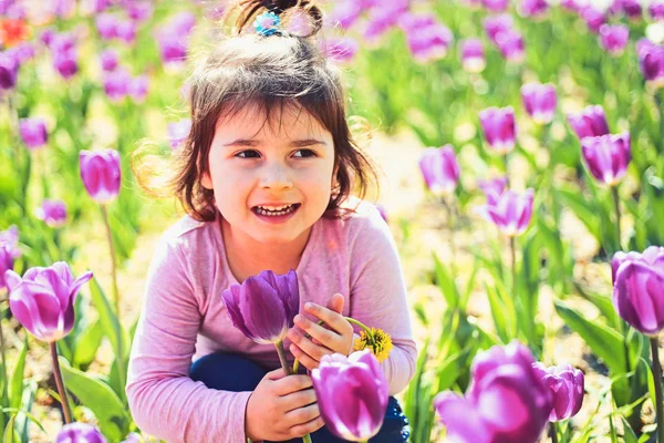 Jarní krásy. Malá holčička v jarní Slunečné. Letní móda dívka. Šťastné dětství. kosmetika obličej. alergie na květiny. Jarní tulipány. Předpověď počasí. Malé dítě. Přírodní krásy. Den dětí — Stock fotografie