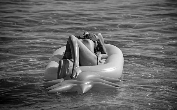Летний образ жизни довольно веселой девушки, плавающей на воздушном матрасе в океане, носящей бикини — стоковое фото