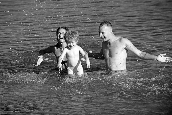 Happy Young Family con Little Kid Divertirsi in spiaggia. Famiglia gioiosa. Viaggi e vacanze. Vacanze estive . — Foto Stock