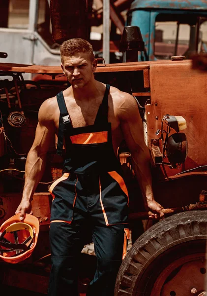 Man concept. Handsome man empoyee rest at tractor cabin. Confident man worker at backhoe loader. Strong man in working uniform at heavy construction machine — Stock Photo, Image