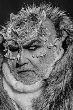 Siyah arka plan, cehennemdeki şeytanlar kapatın. Karanlık sanatlara kavramı. Beyaz sakallı komuta sizde canavar gibi giyinmiş. Dikenler veya siğiller kürk paltolu adam. Uzaylı, iblis, büyücü makyaj.