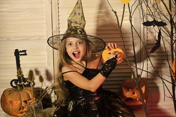 Dziecko w czarownica kapelusz i strój posiada jack o lantern — Zdjęcie stockowe