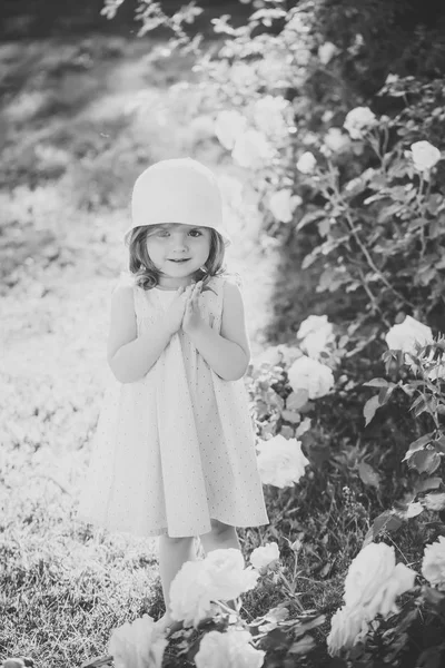 Meisje in de hoed met de handen in de zomertuin bidden — Stockfoto