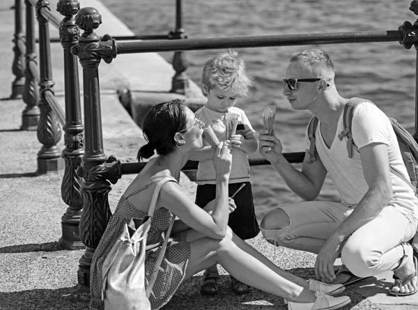 Madre e padre con figlio mangiano il gelato in mare. Vacanze estive di famiglia felice. Bambino con padre e madre. I viaggi di famiglia con bambino durante giorno di padri o madri. Amore e fiducia come valori familiari . — Foto Stock