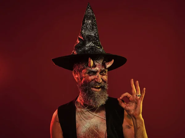 Člověk Halloween s rohy ďábel v witch hat Ukázat ok — Stock fotografie